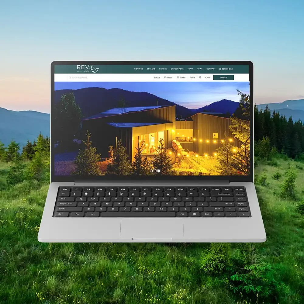 Laptop mockup showing the REVcody real estate website homepage.