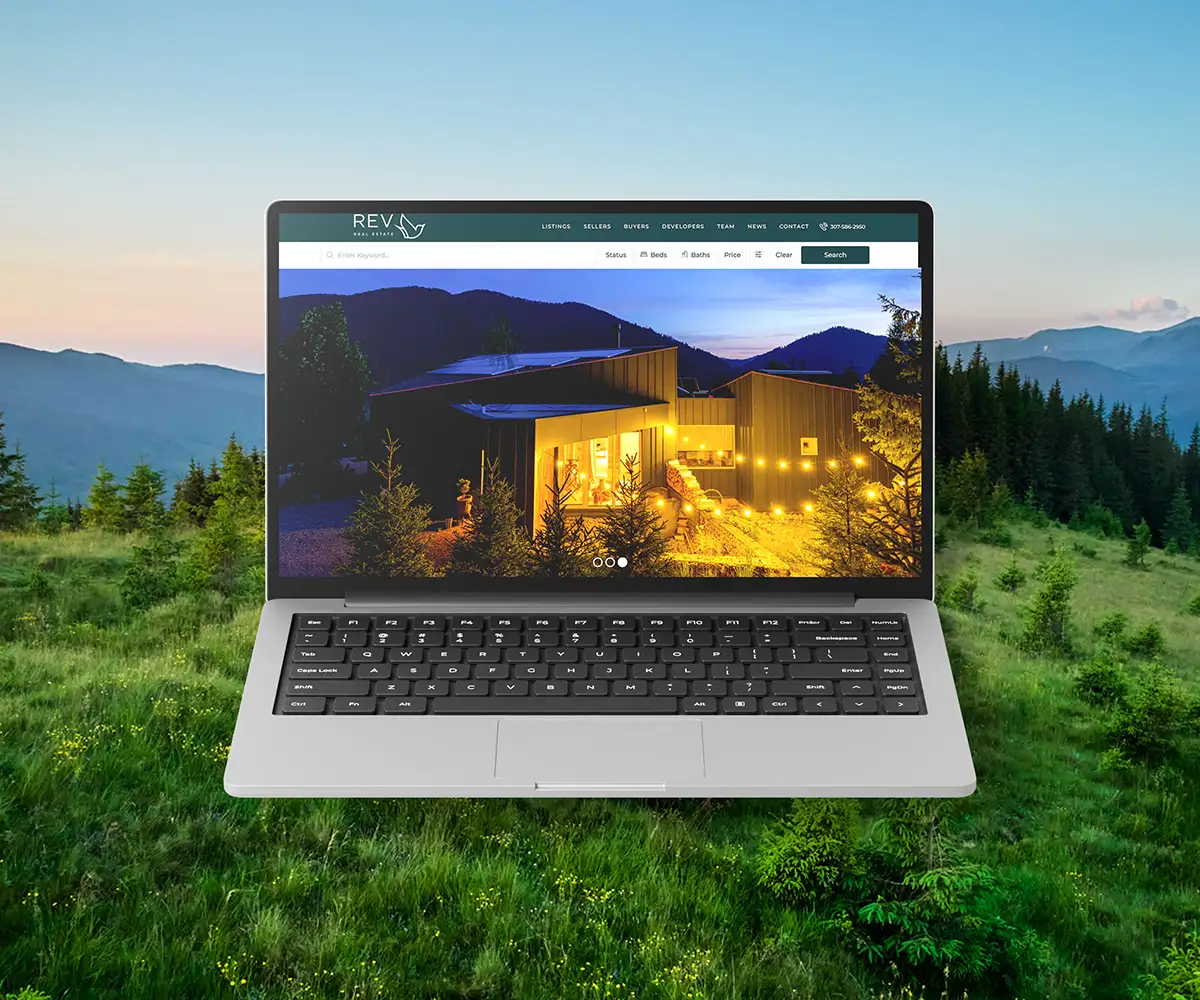 Laptop mockup showing the REVcody real estate website homepage.