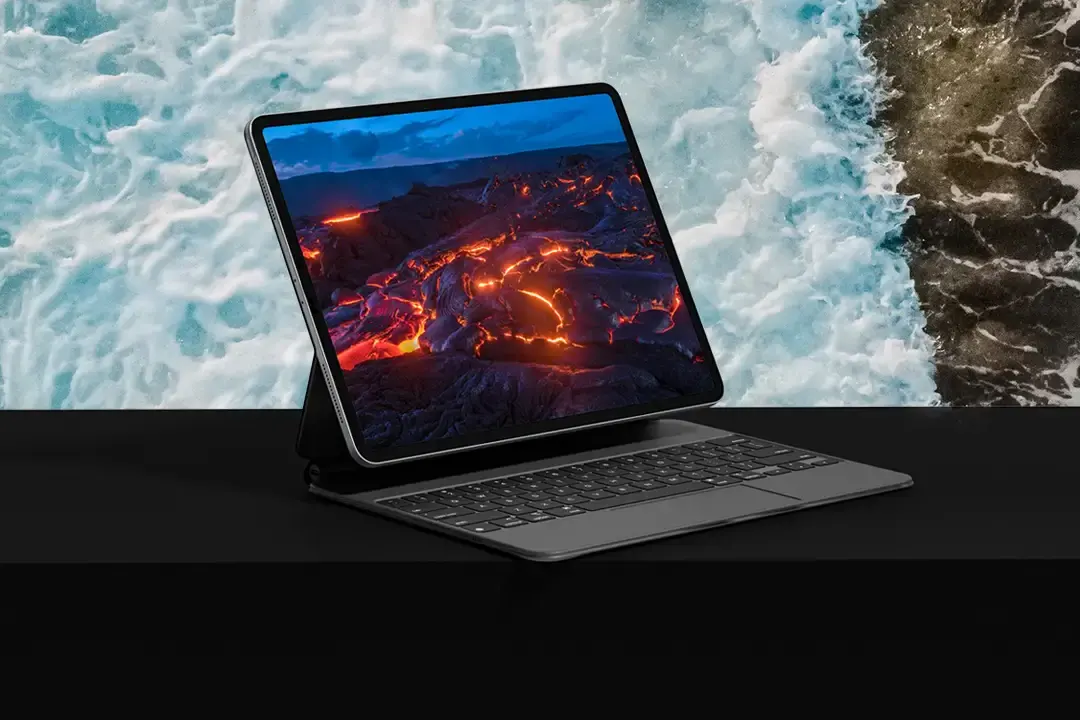 Laptop displaying a colorful digital experience above a waterfall