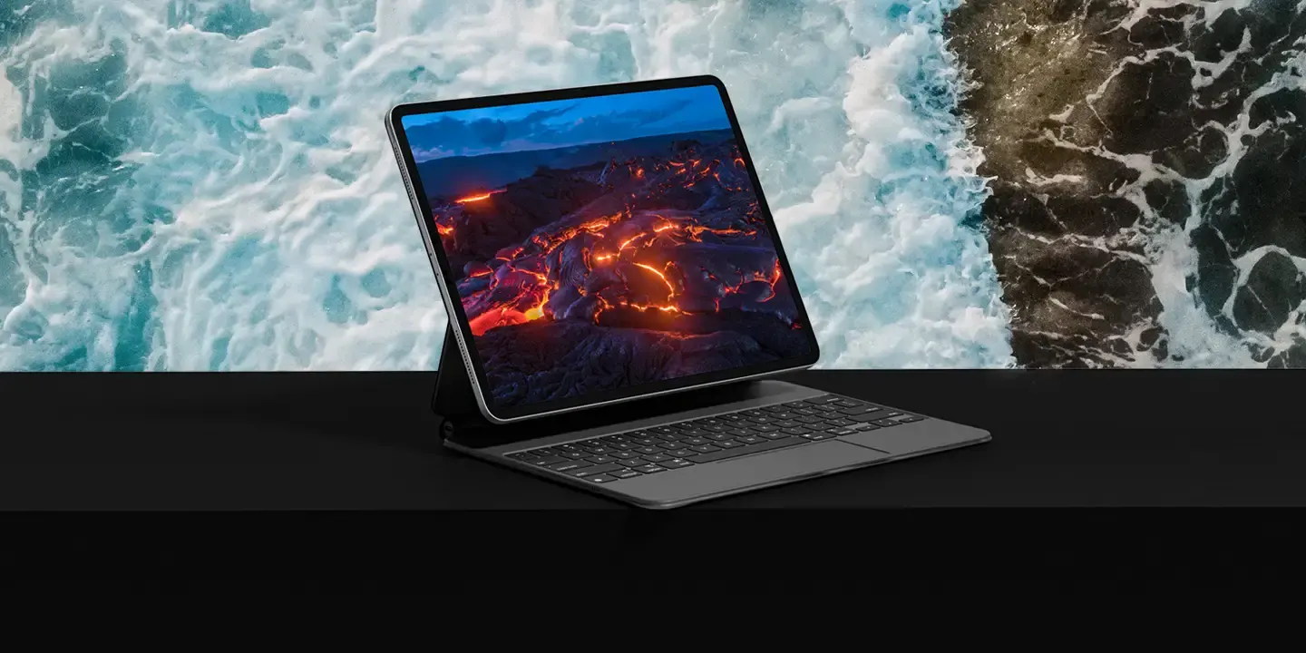 Laptop displaying a colorful digital experience above a waterfall
